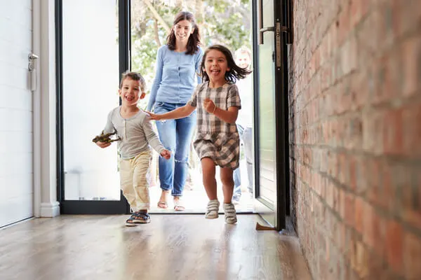 Family entering home through a door